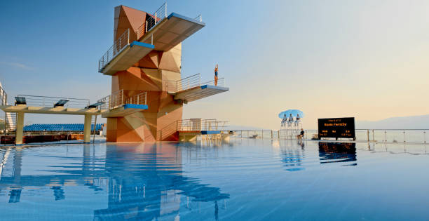 istock Female diver standing on diving board before jump 1135964391