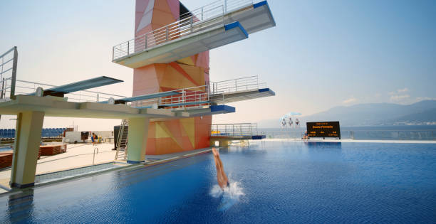 istock Female diver diving into swimming pool 1135964397