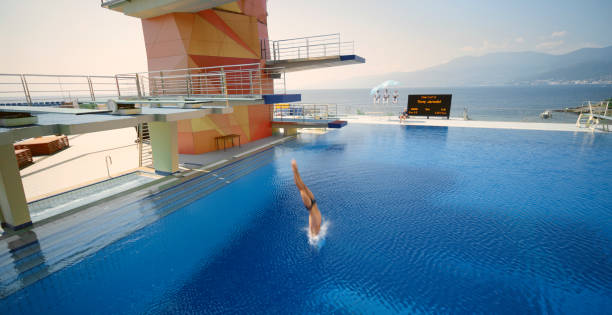 istock Male diver diving into swimming pool 1135964399