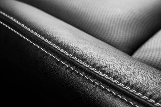 istock Black leather interior of a car. Perforated Leather comfortable seats with stitching isolated on black background. Car interior details. Car detailing. Car inside 1135964523