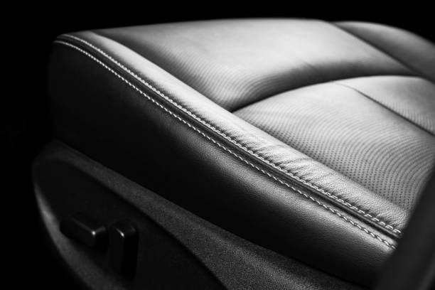 istock Black leather interior of a car. Perforated Leather comfortable seats with stitching isolated on black background. Car interior details. Car detailing. Car inside 1135964649
