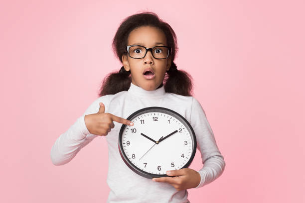 menina surpreendida do african-american que prende o pulso de disparo grande e que aponta nele - countdown leader - fotografias e filmes do acervo