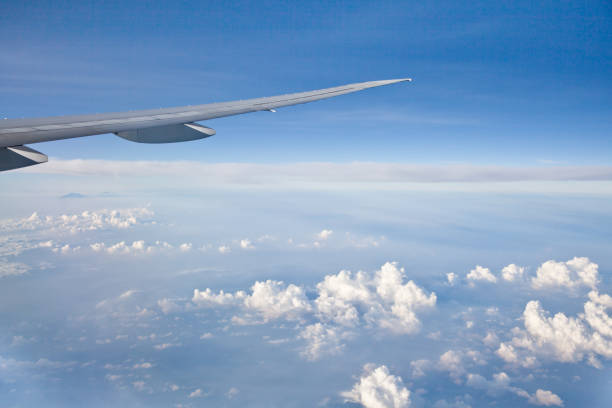 istock Blue sky with white clouds and the wing of the plane. 1135969299