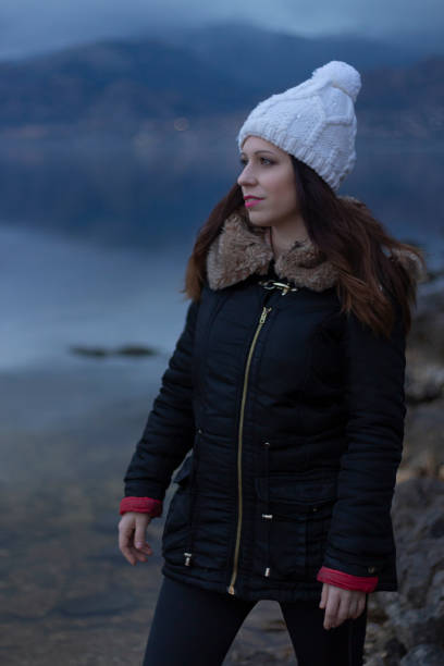 istock Young girl facing a lake during a cloudy day 1135969311
