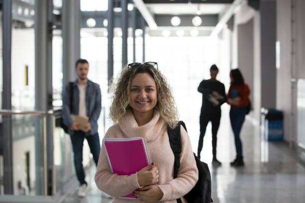 istock Portrait of smiling university student standing in corridor during break 1135969356
