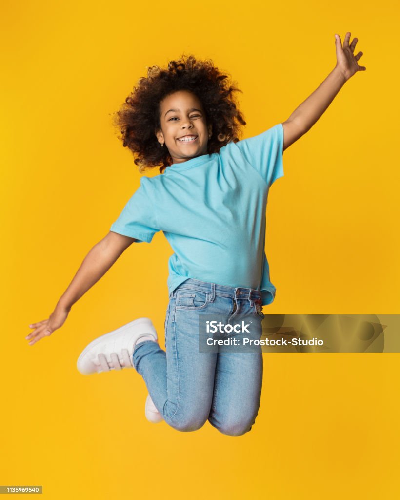 Little Africanamerican Girl Jumping Over Studio Background Stock ...