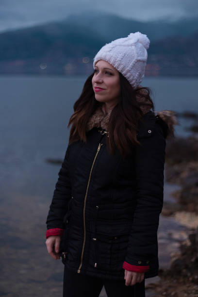 istock Young girl facing a lake during a cloudy day 1135970730