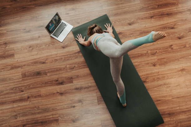 istock Lady stending on one legged dolphin yoga pose 1135972925