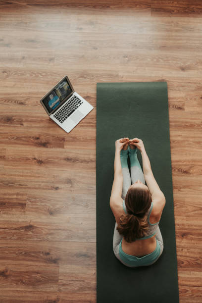 istock Young woman in seated forward bend yoga pose 1135972936