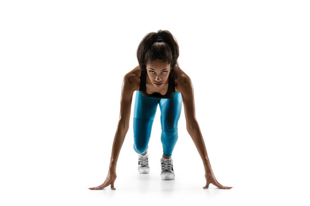jeune femme africaine exécutant ou jogging d'isolement sur le fond blanc de studio. - athlete sport starting line muscular build photos et images de collection