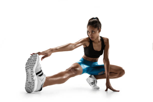 jeune femme africaine d'isolement sur le fond blanc de studio. - muscular build action human muscle black and white photos et images de collection