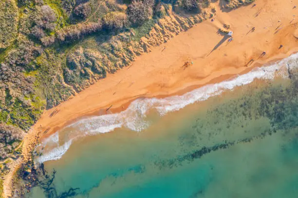 Ramla Bay, a sandy beach between xaghra and nadur in gozo shot overhead, with the sea, waves and beach visible