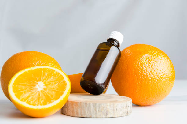 スパサロンでのアロマセラピー。オレンジとオレンジオイルは、木製のボード上のヘルスケアのために、灰色の壁に対して大理石のテーブル - aromatherapy oil massage oil alternative therapy massaging ストックフォトと画像
