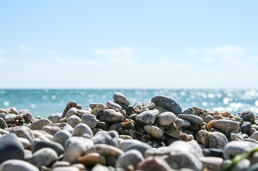 Sea pebbles against a blurred shiny sea