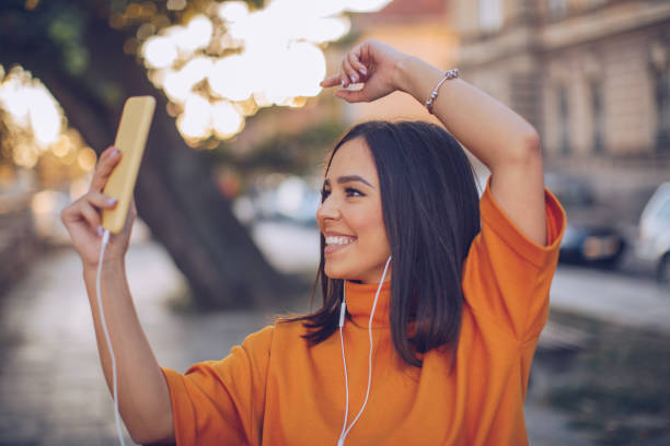 istock Cute young woman using phone on the street 1135980009