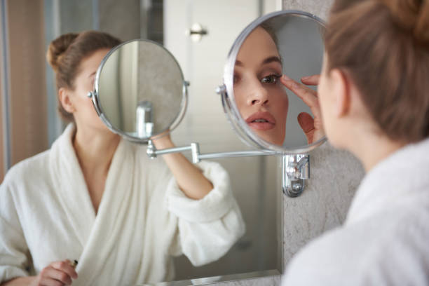 istock Young lady retouching her eyelashes make up 1135983053