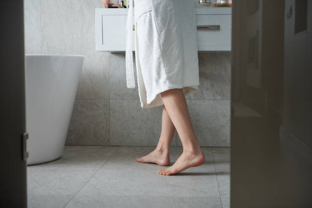 jeune dame aux pieds nus dans la salle de bains près de lavabo - washstand photos et images de collection