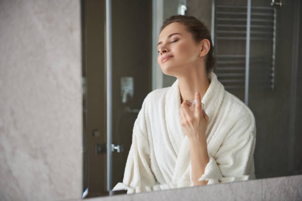 istock Young happy lady enjoying her perfume in morning 1135983075