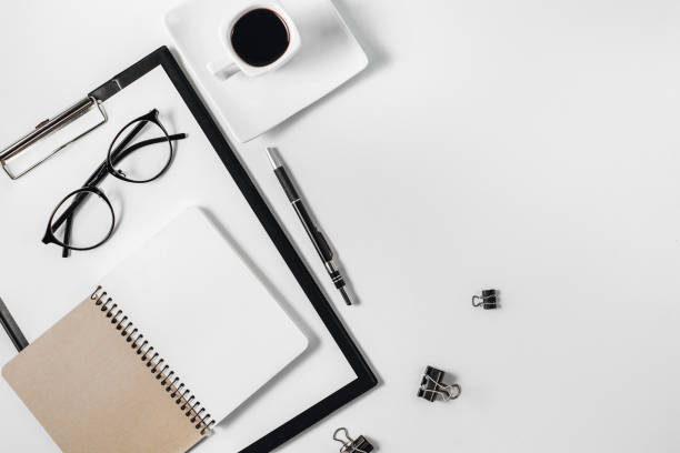 istock Flat lay, top view office table desk. Workspace with blank clip board, watch, office supplies, pen, eyeglasses and coffee cup on white background. Copy space 1135983786