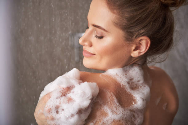 istock Happy smiling lady enjoying shower at home 1135986028
