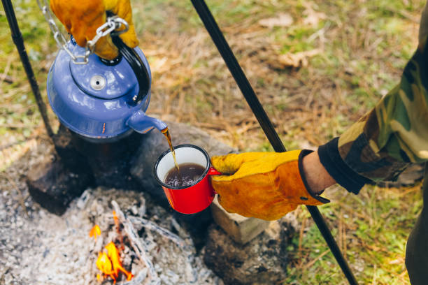 istock Pouring of tea from a thermos on a camping 1135986163