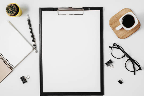 istock Flat lay office workspace with blank clip board, office supplies, pen, cactus, coffee cup and eyeglasses on white background. Top view minimal mock up template concept, copy space 1135986591