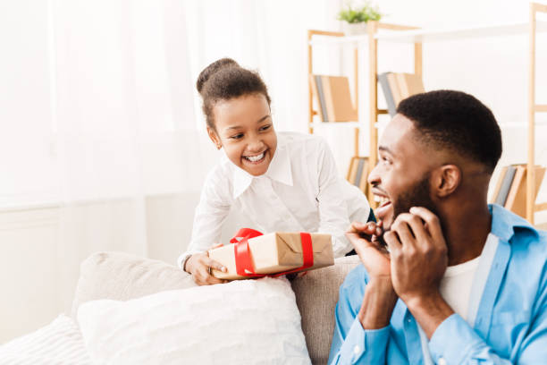 istock Father's day. Happy daughter giving gift box 1135987480