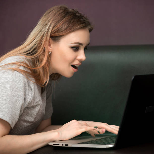 istock Girl in home clothes working with a laptop. 1135987658