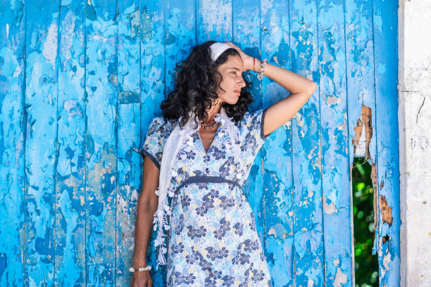 istock Mid adult woman leaning back on blue wall 1135989473