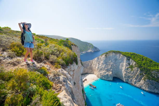 istock Backpacker standing arms outstretched and looking the sea 1135989486