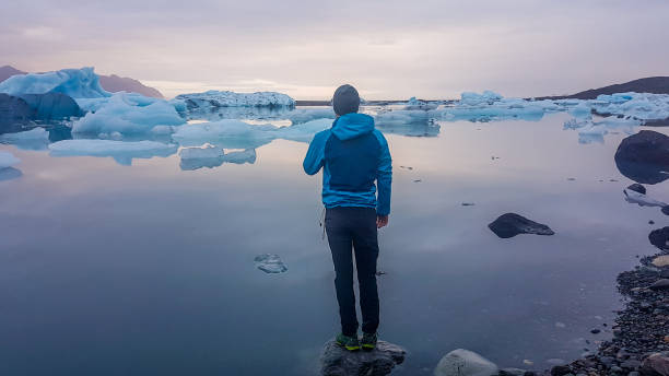 istock Iceland - young man standing on a rock at Glacier Lagoon 1135990933