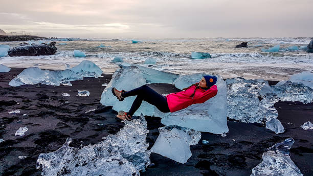 istock Iceland - Girl resting on an ice berg 1135991105