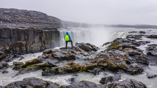 istock Iceland - Man standing on top of a waterfall 1135991818