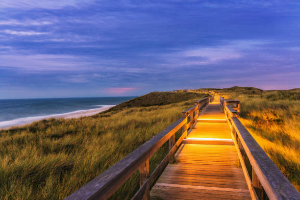 Illuminated wooden path on the sandunes at Wenningstedt, Westerland/Sylt