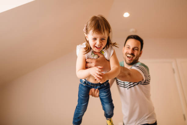 istock Young father is holding his daughter in his hands while enjoying their time together 1136001330