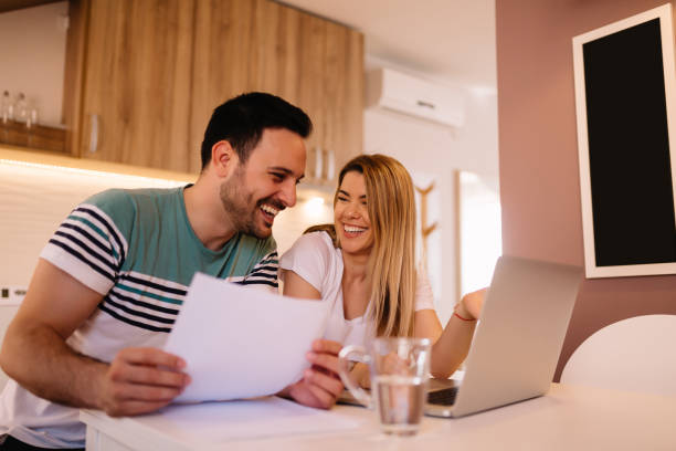 istock Happy young couple calculating bills at home 1136001335