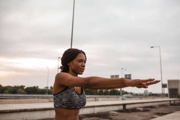 istock Young african american woman doing warming up and stretching 1136001347