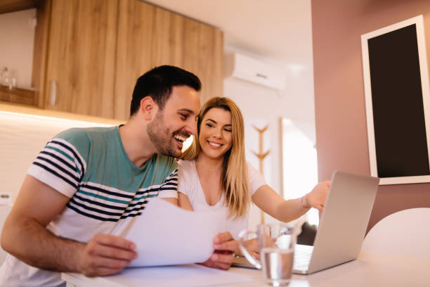 istock Happy young couple calculating bills at home 1136001387