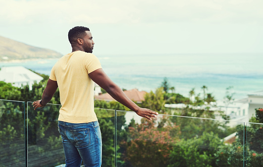 Child watching beautiful mountain and lake view from balcony or patio. Child on house deck. Garden backyard in summer.