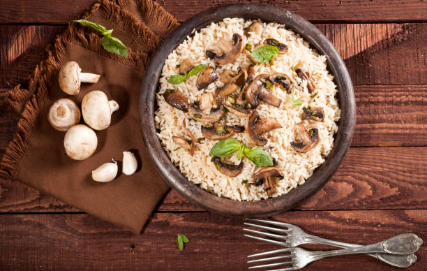 istock Cooked white rice with mushroomsin a bowl on wooden background. 1136002853
