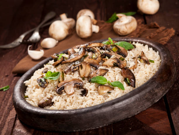 istock Cooked white rice with mushroomsin a bowl on wooden background. 1136002857