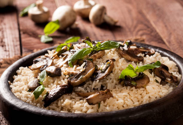 istock Cooked white rice with mushroomsin a bowl on wooden background. 1136002863
