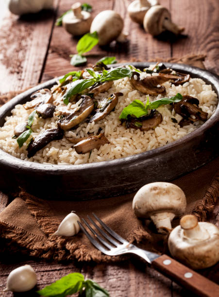 istock Cooked white rice with mushroomsin a bowl on wooden background. 1136002864