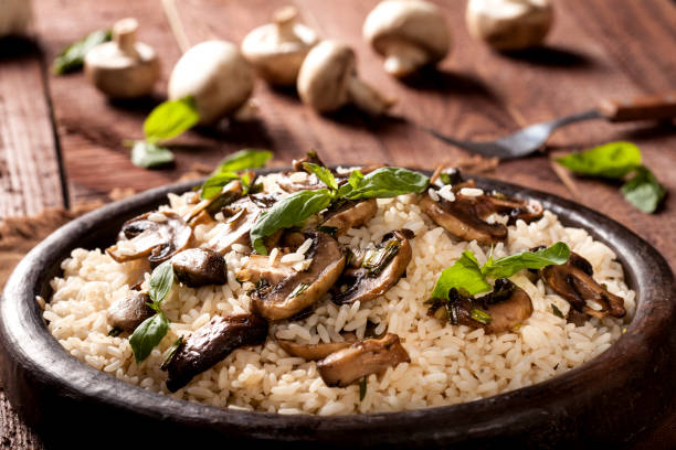 istock Cooked white rice with mushroomsin a bowl on wooden background. 1136002866