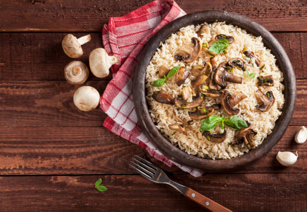 istock Cooked white rice with mushroomsin a bowl on wooden background. 1136002871