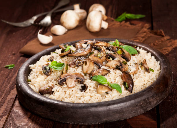 istock Cooked white rice with mushroomsin a bowl on wooden background. 1136002872