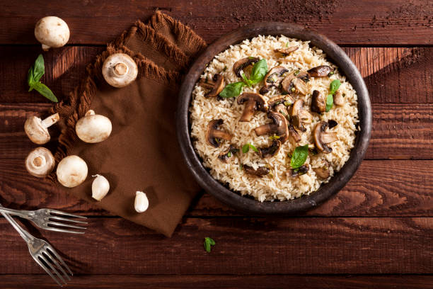 istock Cooked white rice with mushroomsin a bowl on wooden background. 1136002875