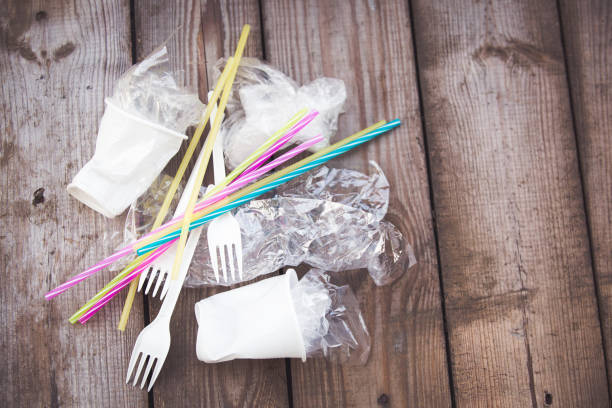 istock Plastic on wooden background, plastic pollution concept 1136002915