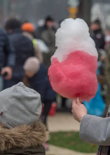 Jozefow, Poland - November 11, 2018: Children with white and red cotton candy in the colors of the polish flag. Celebration of 100 anniversary of Polish independence. Poland