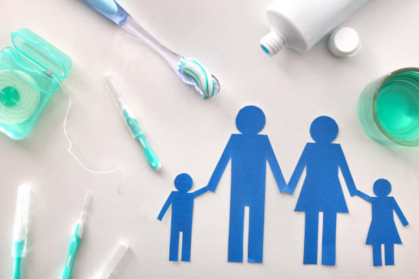 Concept of oral hygiene for the family with tools and products on white table. Horizontal composition. Top view